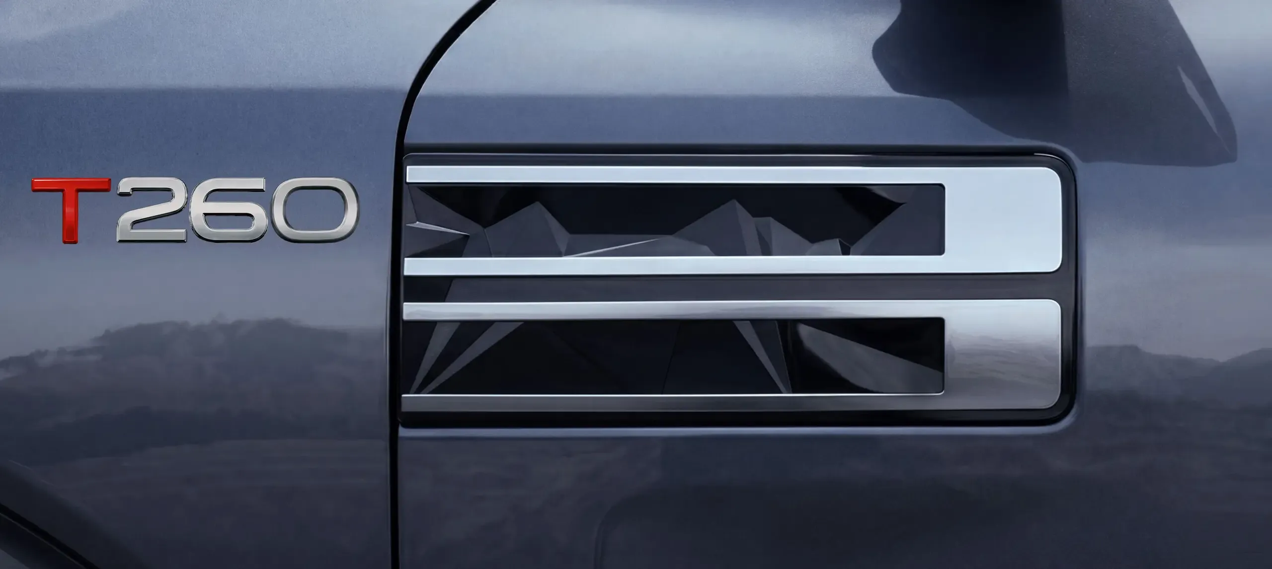 Close-up of the Nissan Tekton T260 badge and its mountain-inspired side detail