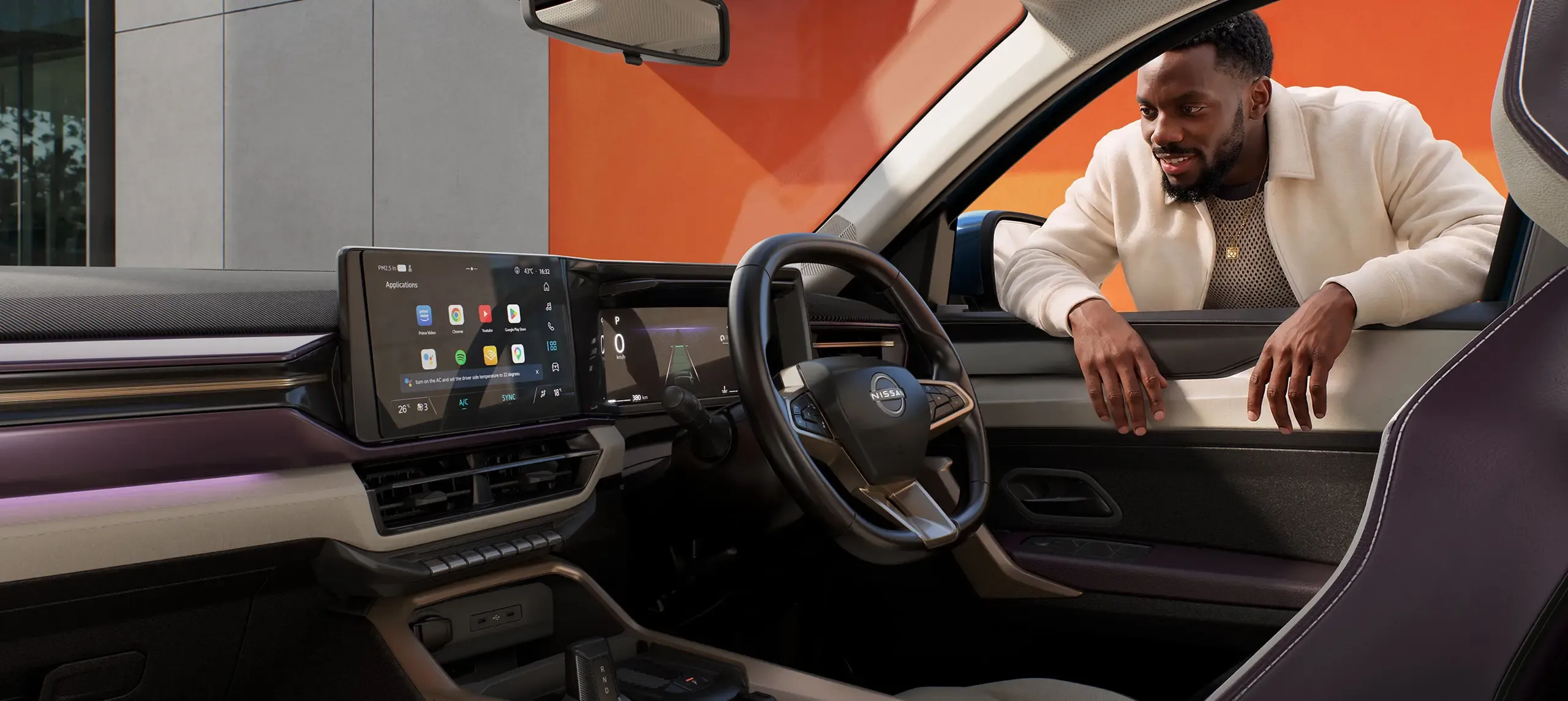Driver leaning in at the window of the Nissan Tekton, looking at the touchscreen and digital cluster